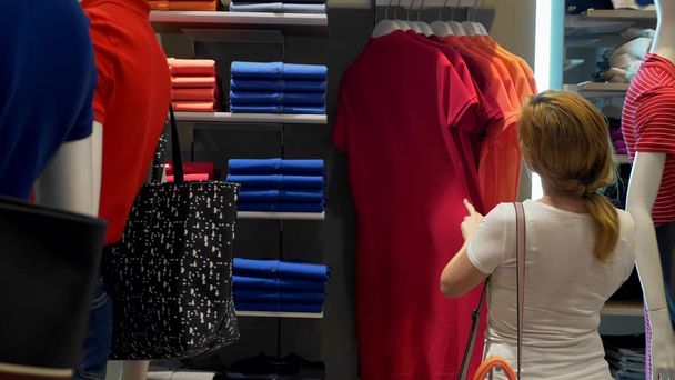 eladó, a divat, a fogyasztás nő választott ruhát a mall fogalmának ruhaüzlet - Fotó, kép