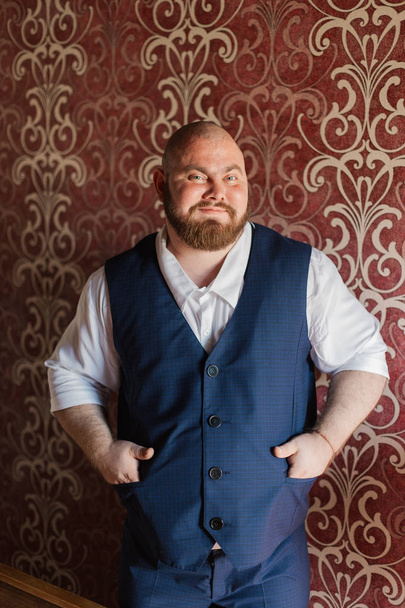 Portret van een dikke man met bretels op zijn broek. - Foto, afbeelding