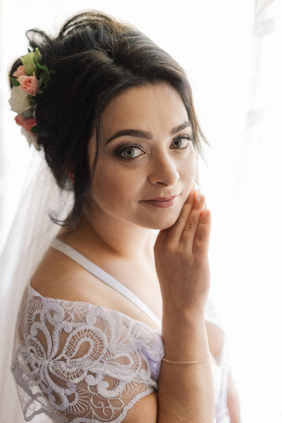 fashion photo of beautiful bride with dark hair in elegant wedding dress and diadem posing in room in the wedding morning. - Foto, immagini