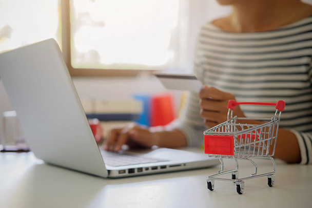 Een jonge vrouw met een creditcard en een laptop. Online winkelen concept - Foto, afbeelding