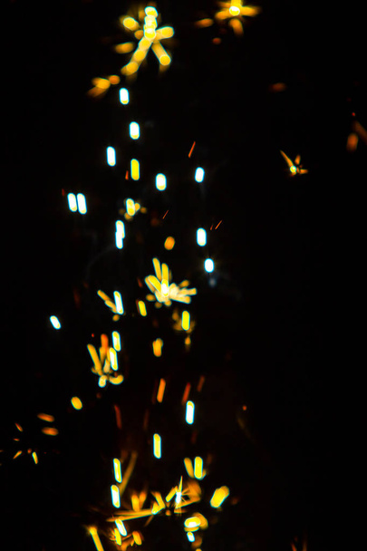 Sfocato, scintille di fuoco su uno sfondo nero, bokeh luminoso, sfondo sfocato di fuoco
. - Foto, immagini
