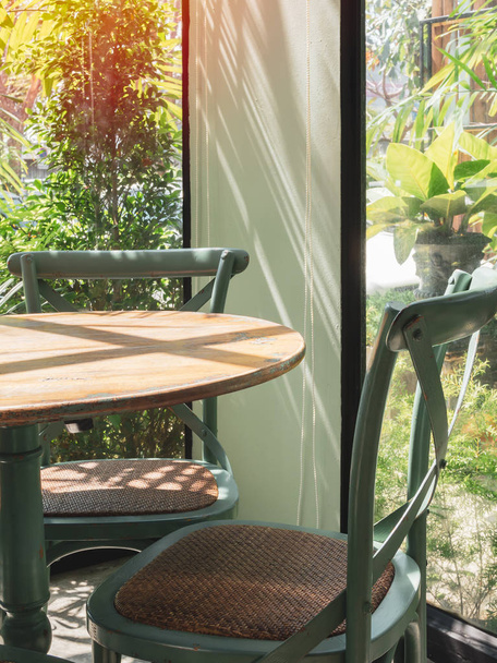 Vintage wooden table and chair in glass room near the garden - Photo, Image