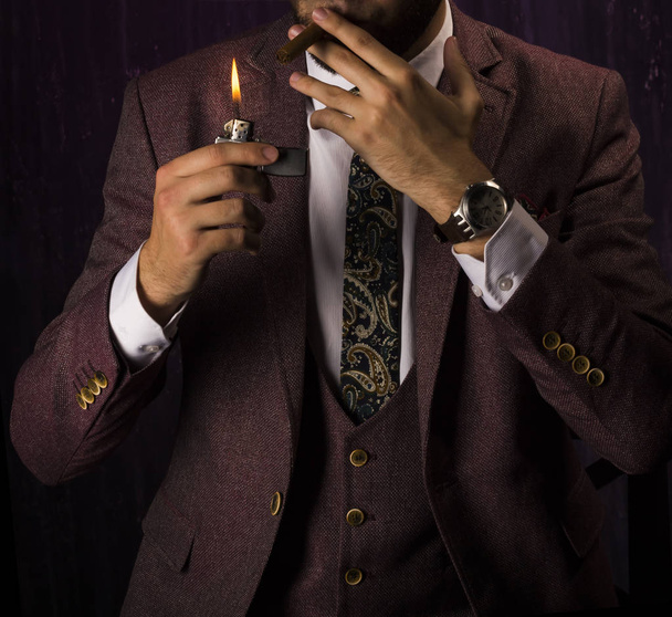 homme d'affaires en costume marron allume un cigare
 - Photo, image