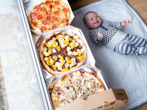 Vegyes verseny Baby vegyes verseny ázsiai kaukázusi fiú mellett nagy pizza, nagyon meglepett a mérete. meglepett gyerek, kisfiú - Fotó, kép