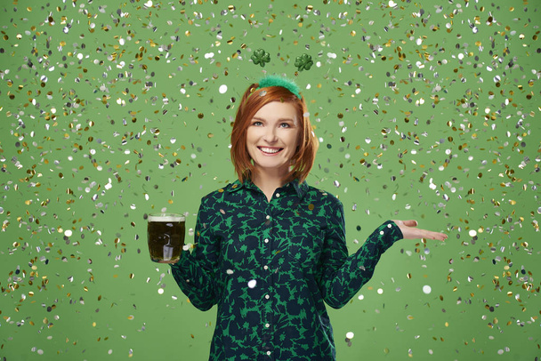 Portrait of woman with beer under a shower of confetti  - Photo, Image