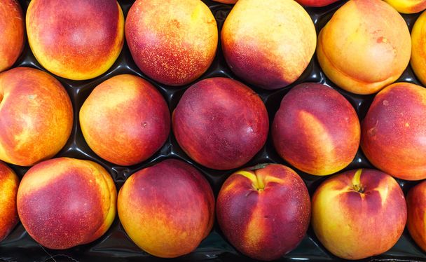 Red-yellow nectarines in a drawer on the table - Photo, Image