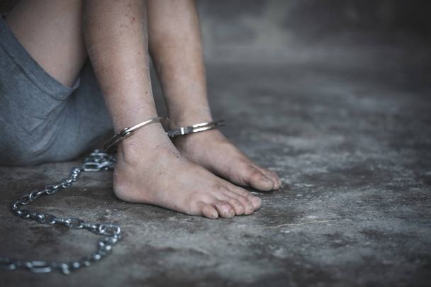 Hopeless child's foot locked with handcuffs, human trafficking,  - Photo, Image