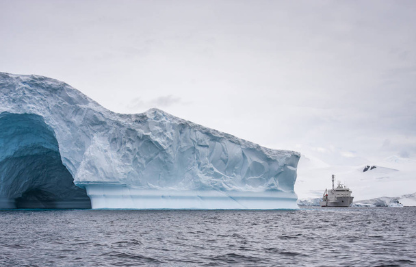 лодка посреди массивных ледников у берегов Антарктического полуострова
 - Фото, изображение