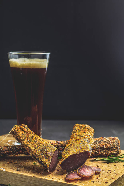 Dark beer in glass and Jerky, basturma, dried meat beef - Photo, Image