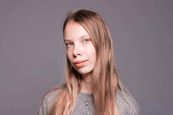 Young girl with long blond hair in the studio - Fotó, kép