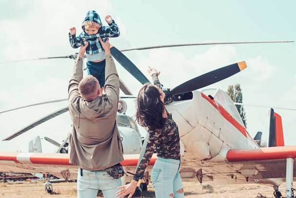 Flying like a bird. Woman and man with boy child at helicopter. Happy family vacation. Family couple with son on vacation travel. Air tour and travel. Enjoying travelling by air - Zdjęcie, obraz