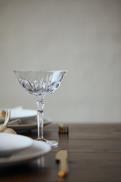 selective focus of crystal glass, plates and cutlery on wooden table in restaurant - Фото, зображення