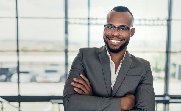 Retrato de un empresario negro confiado sonriendo con los brazos cruzados
 - Foto, imagen