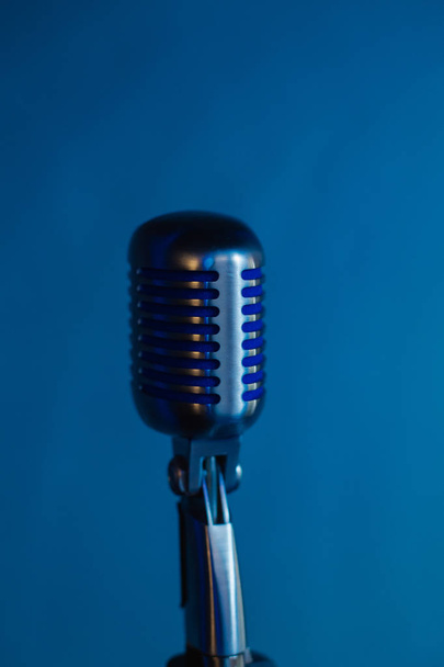 Microphone rétro sur fond de restaurant de lumière bleue tamisée
. - Photo, image