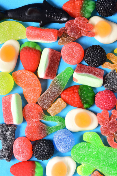 bovenaanzicht van jelly snoepjes collectie op blauwe achtergrond - Foto, afbeelding
