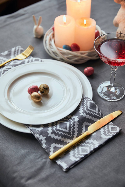 foyer sélectif des assiettes avec serviette en tissu, oeufs dans le panier, vin en verre de cristal sur la table à la maison
 - Photo, image