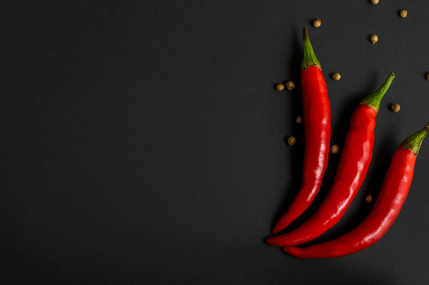 Chili pepper and coriander on a black background. With copy space. Flat-lay, top view. - Foto, Imagem