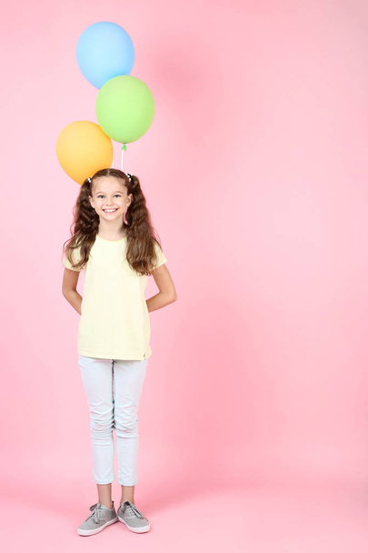 Cute young girl with colored balloons on pink background - Foto, Bild