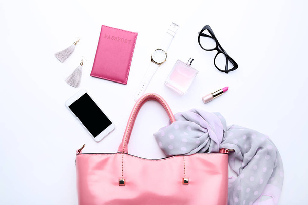 Handbag with smartphone, cosmetics and scarf on white background - Fotó, kép