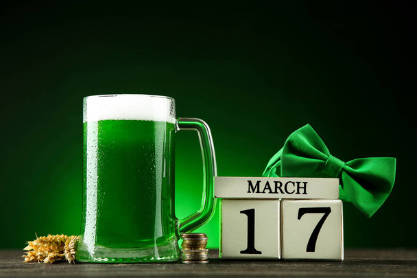 St. Patrick's Day. Green beer in mug with cube calendar, coins a - Foto, Bild