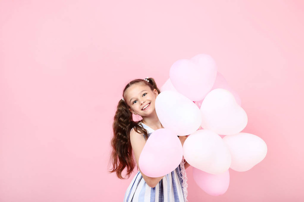 Young girl with balloons on pink background - Photo, Image