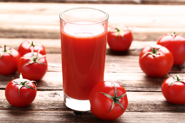 Tomato juice in glass on brown wooden table - Valokuva, kuva