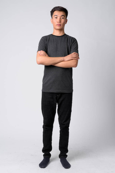 Full body shot of young handsome Asian man with arms crossed - Foto, imagen