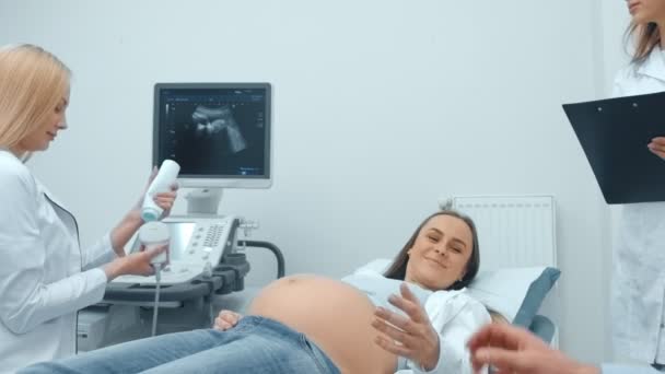 Zbliżenie, lekarz i pacjent w biurze diagnostyki ultradźwiękowej. Młoda kobieta w ciąży na recenzję w centrum medyczne - Materiał filmowy, wideo