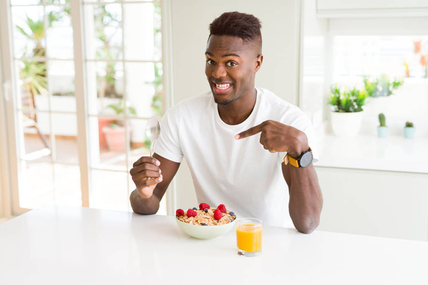朝は非常に幸せな手と指で指している健康的な朝食を食べる若いアフリカ系アメリカ人 - 写真・画像