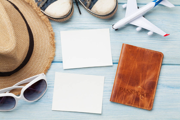 Travel vacation background concept with sun hat and passport with airplane toy and photo frames on wooden backdrop. Top view  - Photo, Image