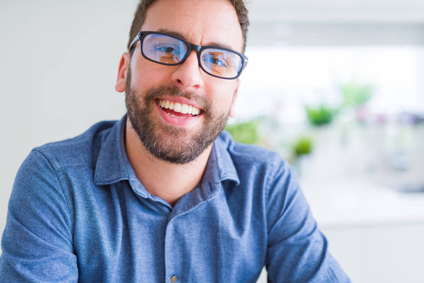 Bonito homem usando óculos e sorrindo relaxado para a câmera
 - Foto, Imagem