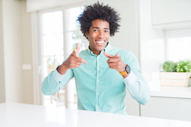 Homem de negócios afro-americano vestindo camisa elegante apontando os dedos para a câmera com rosto feliz e engraçado. Boa energia e vibrações
. - Foto, Imagem