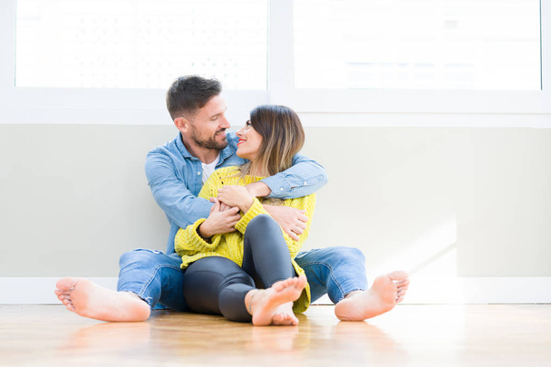 Piękna Młoda para w miłość, Całowanie i przytulanie siebie siedząc na podłodze w domu - Zdjęcie, obraz
