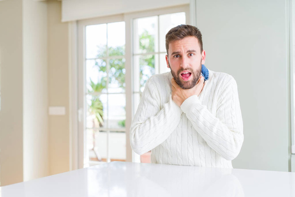Handsome man wearing casual sweater shouting and suffocate because painful strangle. Health problem. Asphyxiate and suicide concept. - Photo, image
