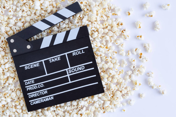 Tasty pop corn and clapperboard abstract on white background. - Foto, Imagen