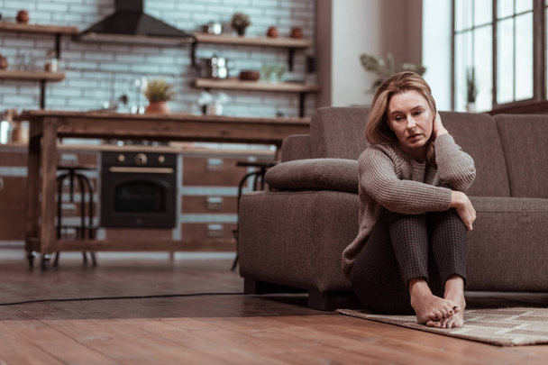 Depressed wife sitting on the floor while feeling stressed - Φωτογραφία, εικόνα