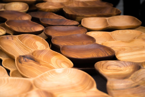 Primer plano de utensilios de madera para la cocina, cuencos, platos sobre fondo oscuro. Concepto de platos naturales, un estilo de vida saludable. Textura de madera. Cubierta ecológica de madera
 - Foto, Imagen