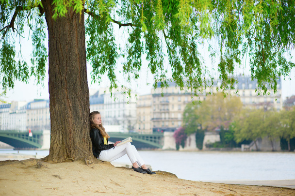 Girl reading a book under the tree - Фото, зображення