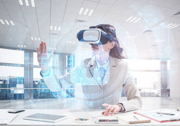 Conceptual image of confident and successful business woman in suit sitting inside office building with security interface and using virtual reality headset - Фото, зображення