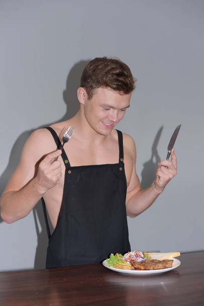 Man is holding knife and fork, he is preparing is eat dish - Fotó, kép
