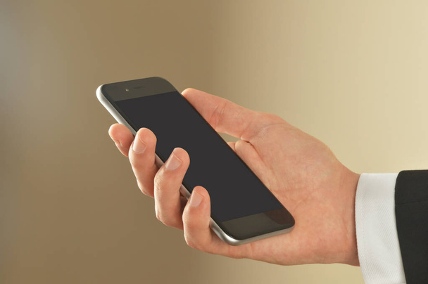 Αρσενική χέρι που κρατά το έξυπνο τηλέφωνο με διαδρομή αποκοπής - Φωτογραφία, εικόνα