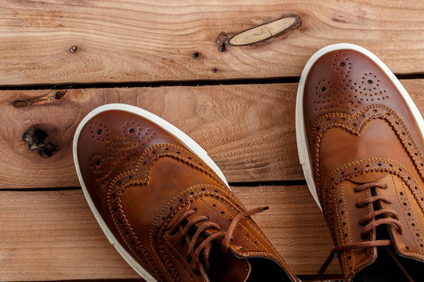 Zapatos de hombre marrón sobre fondo de madera. Vista superior
 - Foto, Imagen