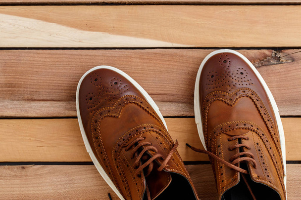 Brązowy buty męskie na podłoże drewniane. Widok z góry - Zdjęcie, obraz