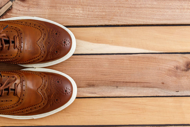 Brown men's shoes on wooden background. Top view - 写真・画像