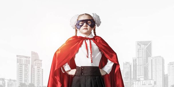 Pequena criança confiante em máscara e capa joga super-herói legal
 - Foto, Imagem