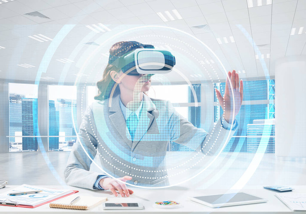 Beautiful and young business woman in suit using virtual reality headset with digital media structure while standing inside office. Up to date security technologies - Фото, изображение