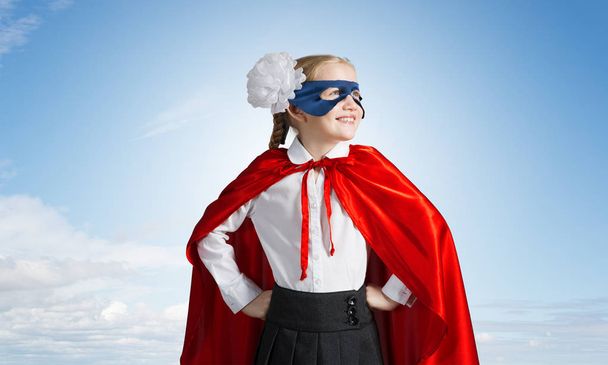 Vertrouwen kindje in masker en cape speelt coole superheld - Foto, afbeelding