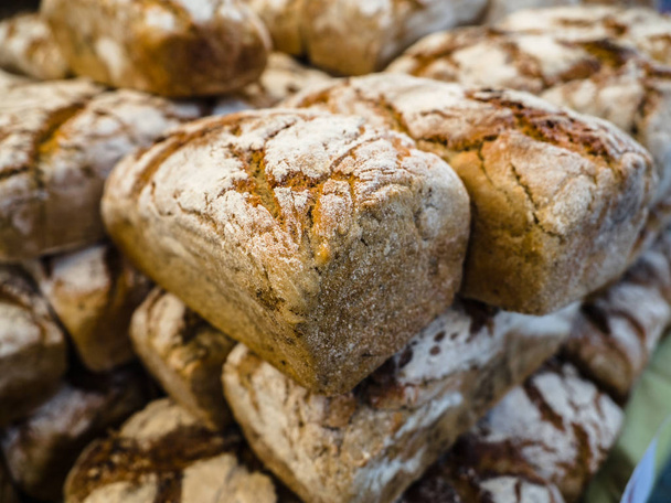 Homemade bread loaves. Fresh bread in bakery background and texture for banner image on website or print media design. Rye bread on market stall. - Photo, Image
