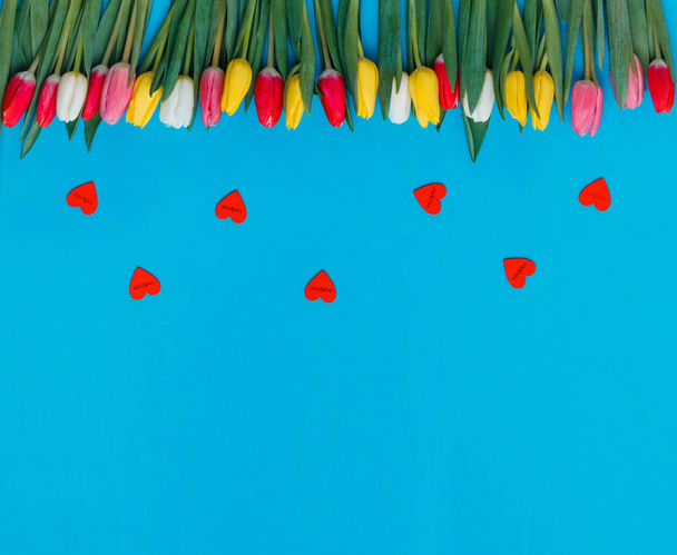 Biglietto di auguri con tulipani e cuori rossi su sfondo blu
 - Foto, immagini