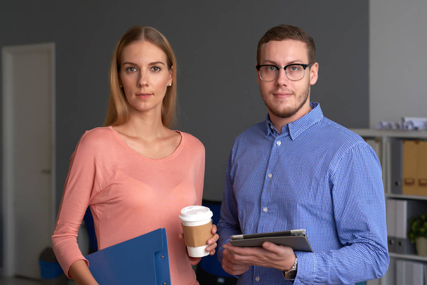 Young business people with coffee, tablet computer and documents in office  - Valokuva, kuva